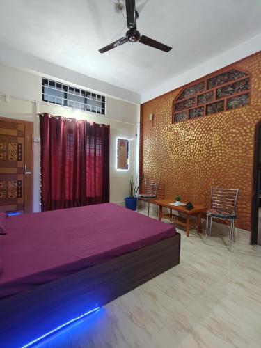 a bedroom with a large bed with a purple blanket at Nest retreat in Jorhat