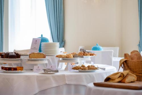 a table with several plates of pastries and bread at Excelsior Palace Hotel in Taormina
