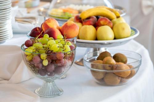 a table topped with bowls of fruit on a table at Excelsior Palace Hotel in Taormina