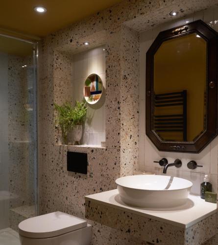 a bathroom with a sink and a toilet and a mirror at The Lakes By YOO in Lechlade