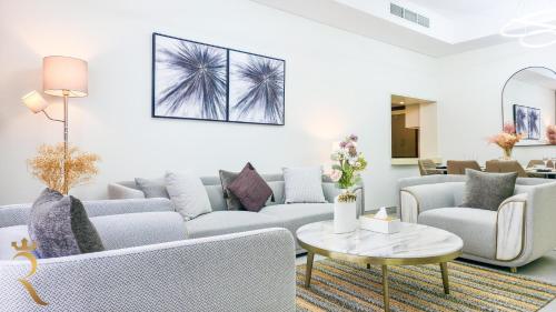 a living room with a couch and a table at 2BR Waterfront Lamar Residences Abu Dhabi in Al Qurayyah