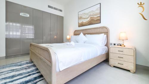 a bedroom with a large bed and a night stand at 2BR Waterfront Lamar Residences Abu Dhabi in Al Qurayyah