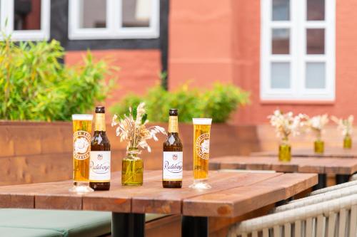 three bottles of beer sitting on a wooden table at Hanse House Wismar in Wismar