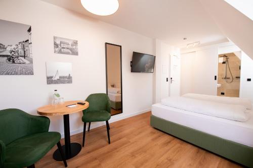 a bedroom with a bed and a table and chairs at Hanse House Wismar in Wismar