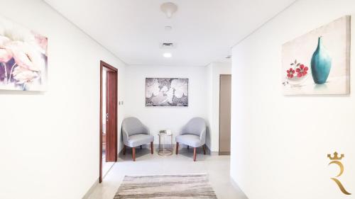 a hallway with two chairs and a table at 2BR Waterfront Lamar Residences Abu Dhabi in Al Qurayyah