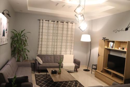 a living room with a couch and a table at HOMEY iNN in Al Madinah