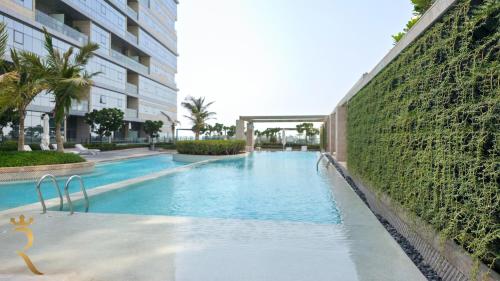 a large swimming pool next to a tall building at 2BR Waterfront Lamar Residences Abu Dhabi in Al Qurayyah
