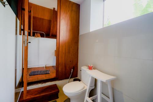 a small bathroom with a toilet and a stool at Ubud Rice Field Stay by WAHM Hotel Management in Ubud