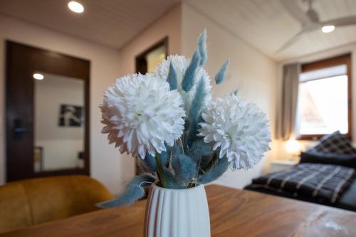 a white vase filled with white flowers on a table at NECKARWESTHEIMER Hotel in Neckarwestheim