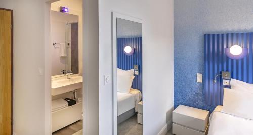 a bathroom with a sink and a mirror at Best Western Poitiers Centre Le Grand Hôtel in Poitiers