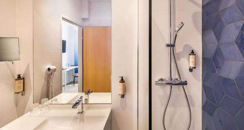 a bathroom with a shower and a sink at Best Western Poitiers Centre Le Grand Hôtel in Poitiers