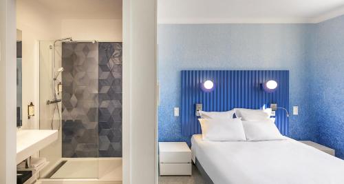 a bedroom with a bed and a bathroom with a shower at Best Western Poitiers Centre Le Grand Hôtel in Poitiers
