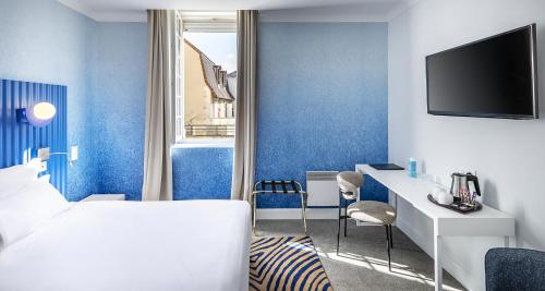 a hotel room with blue walls and a bed and a desk at Best Western Poitiers Centre Le Grand Hôtel in Poitiers