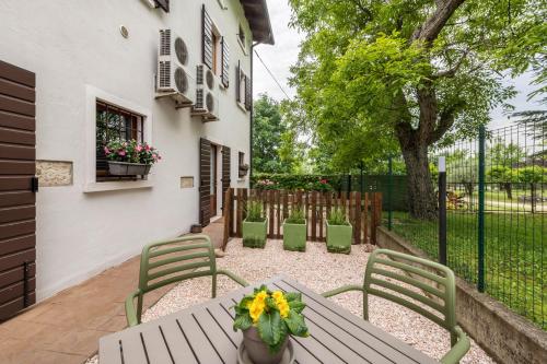 a patio with a table and chairs and a fence at AGRITURISMO COLOMBARE TEBOI in Lazise