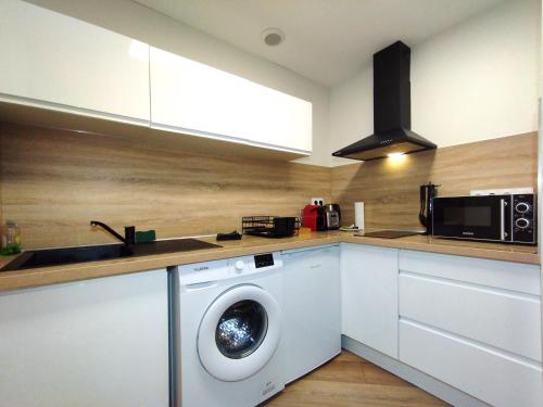 a kitchen with a washing machine and a microwave at Jaurès 3 - appart proche gare in La Roche-sur-Foron