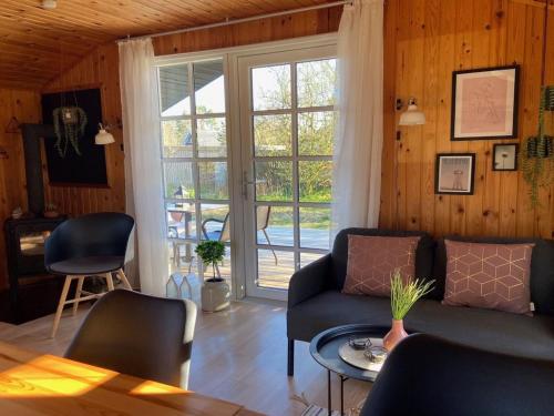 een woonkamer met een bank en een glazen deur bij Holiday Home Imma - from the sea by Interhome in Hals
