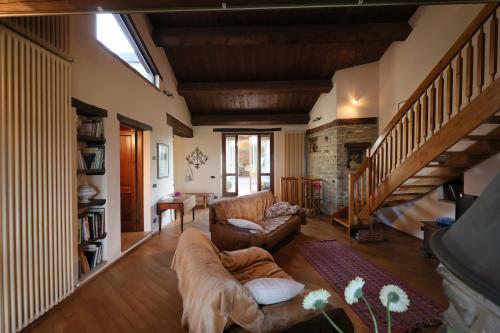 a living room with a couch and a staircase at Splendida casa in sasso in borgo in Canossa