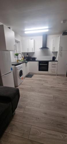 a kitchen with white cabinets and a washer at Peace house in Oldbury