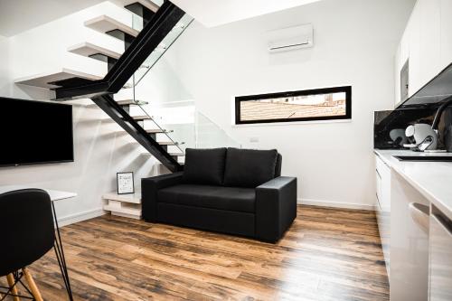 a black chair in a living room with a staircase at Loft Prestige in Leiria