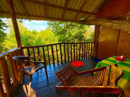 a porch with a table and chairs on a deck at Tree House 4 Nature Lovers in Udawalawe