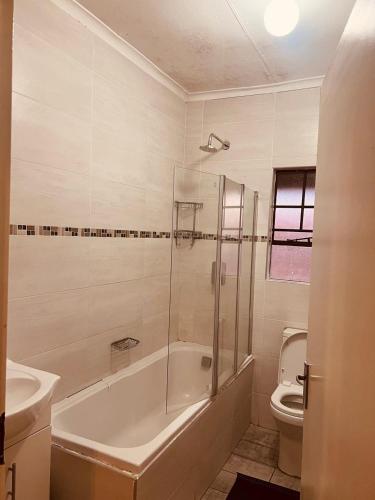 a bathroom with a tub and a sink and a toilet at Mama R's unit 39 in Newcastle