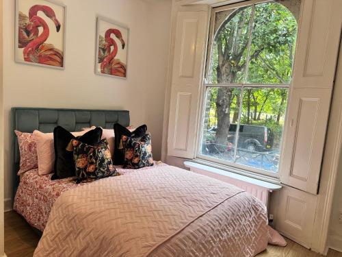 a bedroom with a bed and a large window at Private and Cosy 1 Bed Flat By Burges Park in London