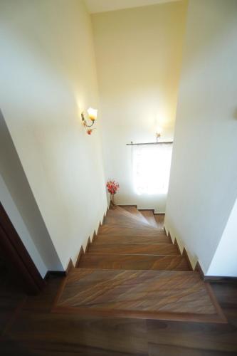 a hallway with a staircase with a white wall and a window at The dreamhouse kastoria in Dhendrokhórion