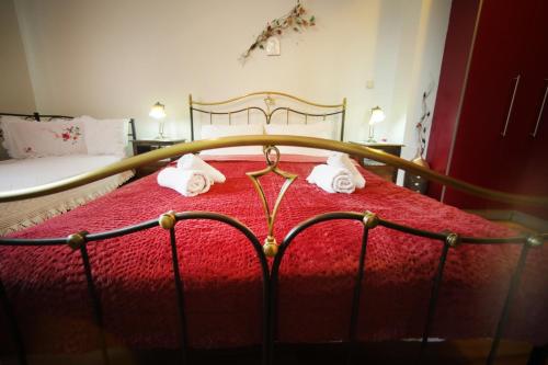 a bedroom with a red bed with towels on it at The dreamhouse kastoria in Dhendrokhórion