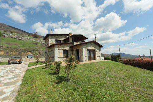 a small stone house on a grassy hill at The dreamhouse kastoria in Dhendrokhórion