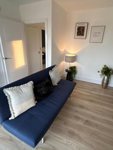a blue couch with pillows in a living room at 1 Great for Contractors 2BR Flat Near Harlow Station in London Stansted Airport