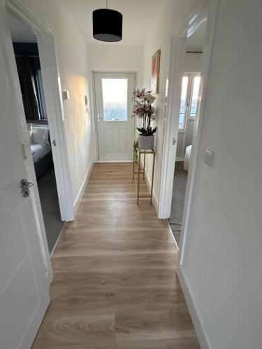 a hallway with white walls and wood floors at 1 Great for Contractors 2BR Flat Near Harlow Station in London Stansted Airport