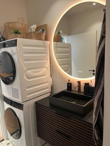 a bathroom with a washing machine and a sink at Stue villa lejlighed med adgang til stor have in Herning