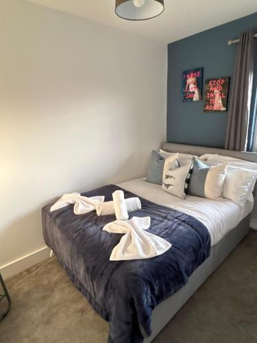 a bedroom with a bed with towels on it at 1 Great for Contractors 2BR Flat Near Harlow Station in London Stansted Airport