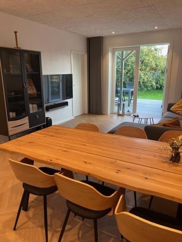 a large wooden table and chairs in a living room at Stue villa lejlighed med adgang til stor have in Herning