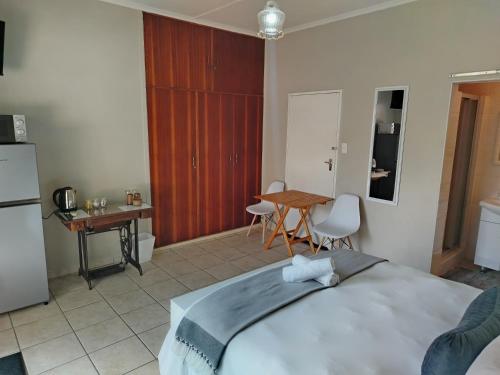 a bedroom with a bed and a table and a kitchen at Novalia in Colesberg