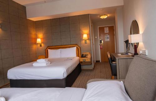 a hotel room with two beds and a sink at Copthorne Hotel Plymouth in Plymouth