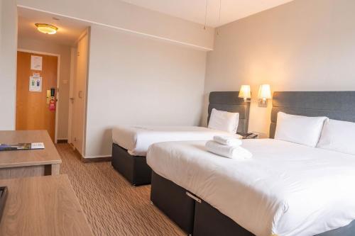 a hotel room with two beds and a table at Copthorne Hotel Plymouth in Plymouth