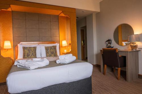 a hotel room with a bed and a desk at Copthorne Hotel Plymouth in Plymouth