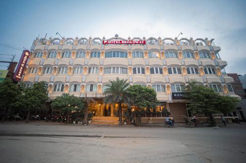 a large white building with a sign on it at New Hotel Broadway in Varanasi