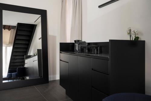 a black kitchen with a mirror and a counter at Casa Guttmann in Rome