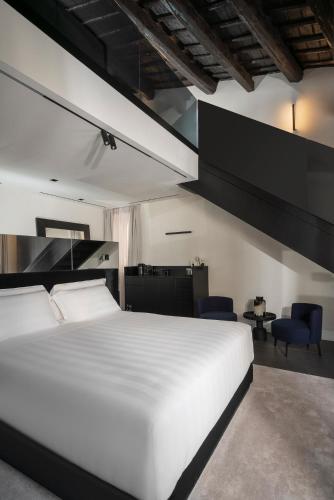 a bedroom with a large white bed and blue chairs at Casa Guttmann in Rome