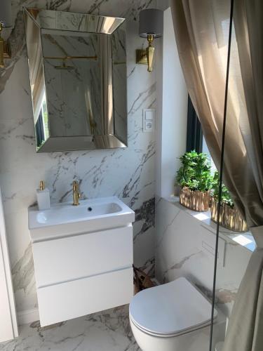 a bathroom with a white sink and a toilet at NAD JEZIORAMI Niedźwiady in Kolonia Pawłówek