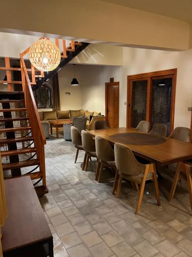 a dining room with a large table and chairs at Villa'S in Zaouiet Bouzarktoune