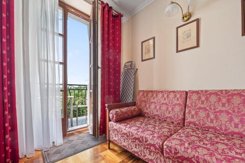 a living room with a red couch and a window at Apartamenty Ucho Igielne in Sandomierz