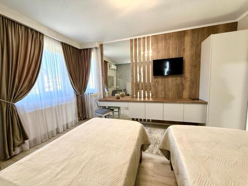 a hotel room with two beds and a television at Hotel Dorobanti in Iaşi