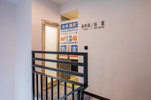 a staircase with a sign on the wall next to a door at BeiJing Seeyou Hostel -Close to the city center Near Subway Line 10 Sanyuanqiao,Close to Sanlitun,Yonghe Lama Temple,Tourism service in Beijing