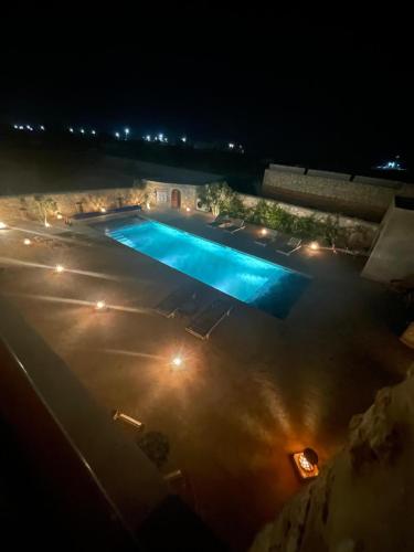 an overhead view of a swimming pool at night at Villa'S in Zaouiet Bouzarktoune