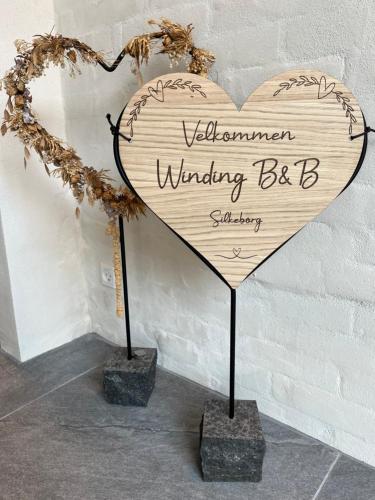 a wooden heart with a sign that reads welcomegiving beb at Winding B&B Silkeborg in Silkeborg
