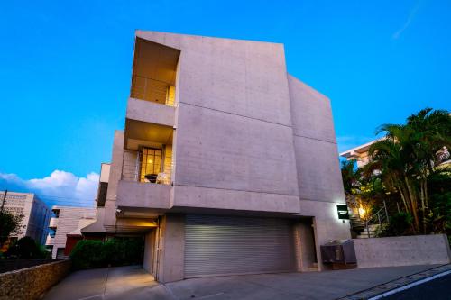 a large building with a garage in front of it at onna resort nakadomari ビーチまで車で4分 最大12名OK 中庭付き貸切ヴィラでくつろぐ恩納村ステイ in Onna