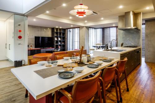 a kitchen with a large white table and chairs at onna resort nakadomari ビーチまで車で4分 最大8名OK 中庭付き貸切ヴィラでくつろぐ恩納村ステイ in Onna